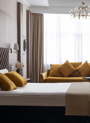 Диван можно расположить в изножье кровати либо параллельно ей, вдоль окна или стены.